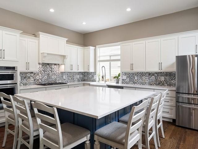 4332 S Greystone Ln, Spokane, WA 99223 - kitchen featuring stainless steel appliances, a kitchen island, decorative backsplash, white cabinets, and recessed lighting