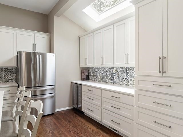 4332 S Greystone Ln, Spokane, WA 99223 - kitchen featuring freestanding refrigerator, tasteful backsplash, light countertops, a skylight, and white cabinetry