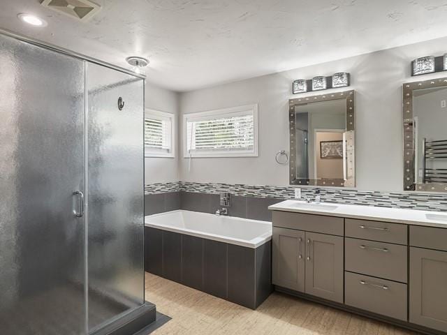 4332 S Greystone Ln, Spokane, WA 99223 - bathroom with wood finished floors, double vanity, a bath, a shower stall, and a towel warmer