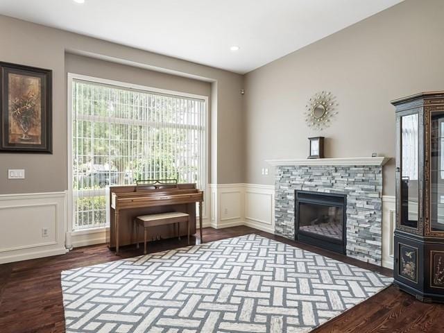 4332 S Greystone Ln, Spokane, WA 99223 - living room featuring wood finished floors, a wainscoted wall, a stone fireplace, a decorative wall, and recessed lighting