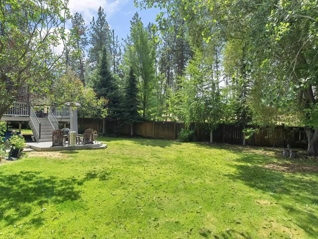 4332 S Greystone Ln, Spokane, WA 99223 - fenced backyard featuring stairs, a wooden deck, and a patio