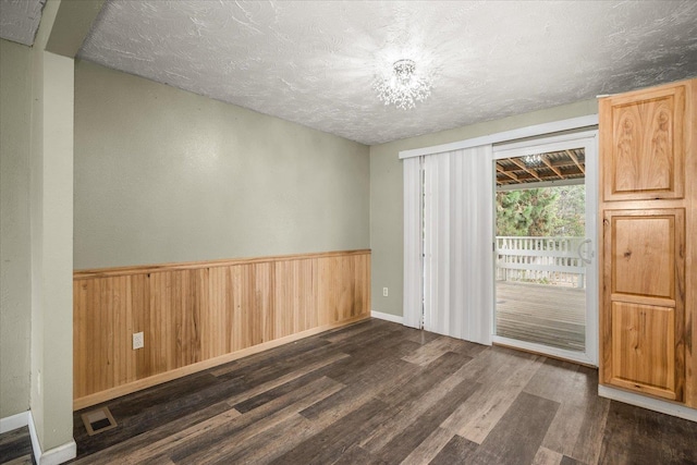 415 E Shiloh Hills Dr, Spokane, WA 99208 - spare room with dark wood-type flooring, a textured ceiling, wainscoting, and wooden walls