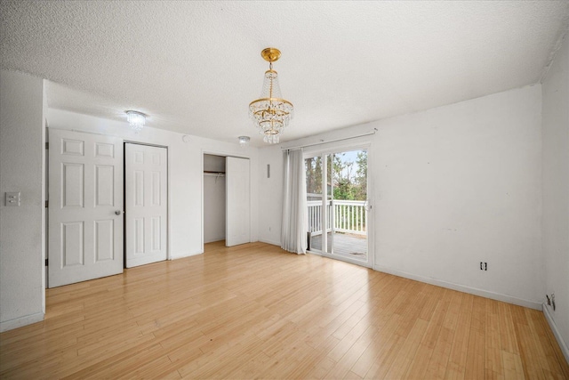 415 E Shiloh Hills Dr, Spokane, WA 99208 - unfurnished bedroom with access to outside, a chandelier, light wood-style flooring, and two closets