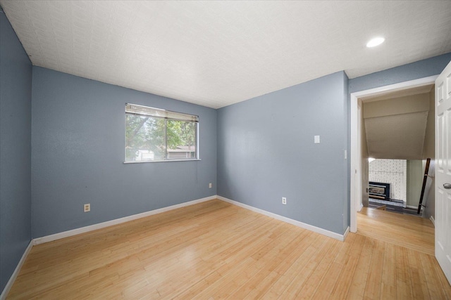 415 E Shiloh Hills Dr, Spokane, WA 99208 - spare room with light wood-type flooring, a fireplace, and recessed lighting