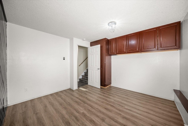 415 E Shiloh Hills Dr, Spokane, WA 99208 - spare room with wood finished floors, stairway, and a textured ceiling