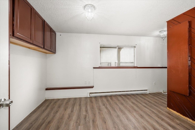 415 E Shiloh Hills Dr, Spokane, WA 99208 - unfurnished room featuring a baseboard radiator, wood finished floors, and a textured ceiling