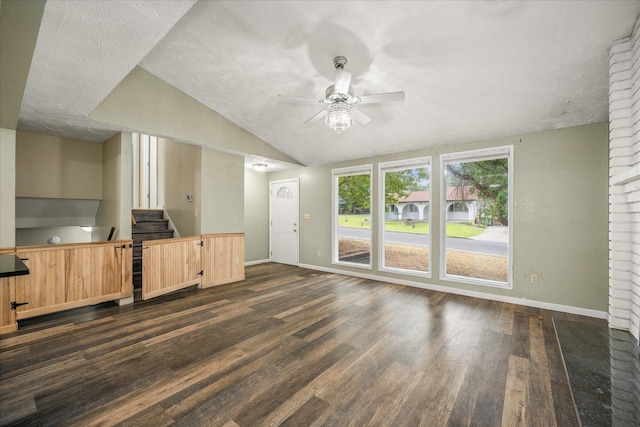 415 E Shiloh Hills Dr, Spokane, WA 99208 - unfurnished living room featuring a ceiling fan, dark wood-style floors, vaulted ceiling, stairs, and a textured ceiling