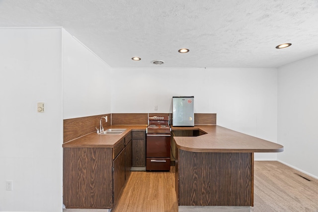 5504 N Post St, Spokane, WA 99205 - kitchen featuring a peninsula, electric stove, a textured ceiling, recessed lighting, and dark brown cabinets