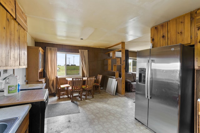 2510 N Rambo Rd, Spokane, WA 99224 - kitchen with stainless steel fridge, wooden walls, brown cabinets, light countertops, and light flooring