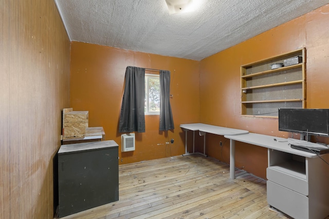 2510 N Rambo Rd, Spokane, WA 99224 - unfurnished office with light wood-style flooring, built in desk, heating unit, and a textured ceiling