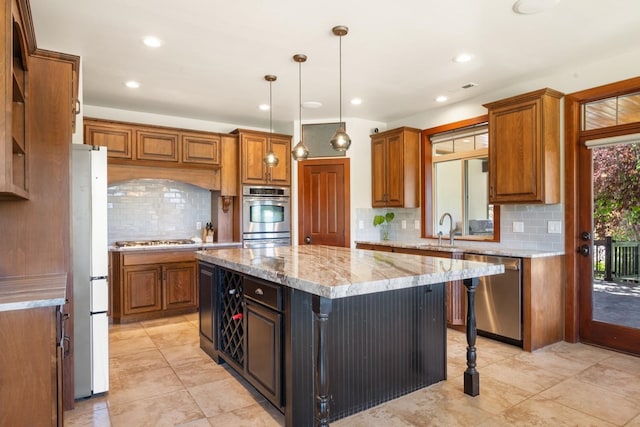 7814 S Ellis Rd, Spokane, WA 99223 - kitchen with stainless steel appliances, brown cabinets, a center island, and recessed lighting