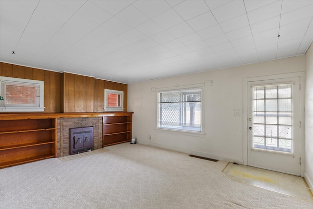 7102 E Bridgeport Ave, Spokane Valley, WA 99212 - unfurnished living room with a fireplace, light carpet, and wood walls