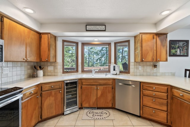 5321 Pinebrook Ct, Spokane, WA 99206 - kitchen with stainless steel appliances, wine cooler, brown cabinets, and recessed lighting