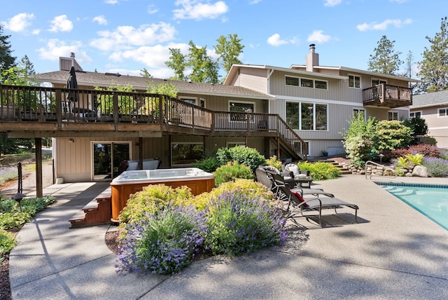 5321 Pinebrook Ct, Spokane, WA 99206 - back of property featuring a hot tub, stairway, a wooden deck, a chimney, and a patio