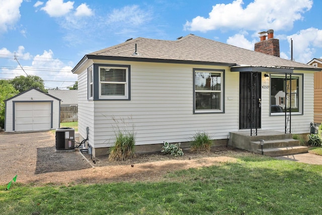 2509 W Upton Ave, Spokane, WA 99205 - view of front of home featuring an outbuilding, a chimney, a front lawn, a garage, and driveway