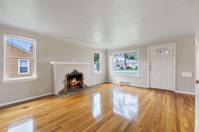 2509 W Upton Ave, Spokane, WA 99205 - unfurnished living room featuring wood finished floors, a fireplace with flush hearth, and a textured ceiling