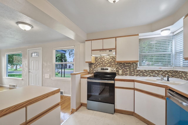 2509 W Upton Ave, Spokane, WA 99205 - kitchen with stainless steel appliances, light countertops, under cabinet range hood, and tasteful backsplash