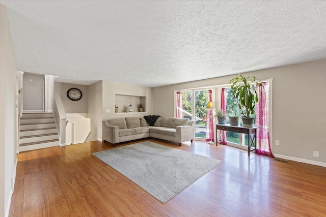 404 E Carriage Ct, Spokane, WA 99218 - living area featuring a textured ceiling, wood finished floors, stairway, and built in shelves