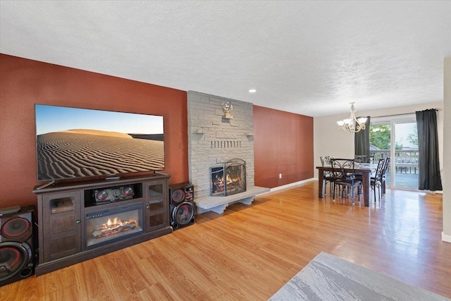 404 E Carriage Ct, Spokane, WA 99218 - living area with a fireplace, a chandelier, wood finished floors, and a textured ceiling