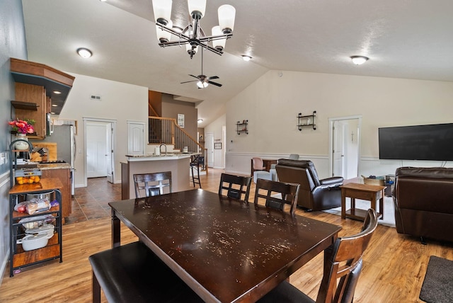 17309 E Baldwin Ave, Spokane Valley, WA 99016 - dining area with a chandelier, stairs, high vaulted ceiling, light wood-style flooring, and wainscoting