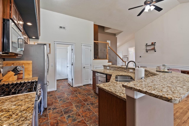 17309 E Baldwin Ave, Spokane Valley, WA 99016 - kitchen featuring stainless steel appliances, a ceiling fan, an island with sink, light stone counters, and high vaulted ceiling