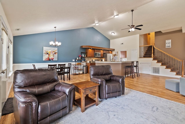 17309 E Baldwin Ave, Spokane Valley, WA 99016 - living room with a chandelier, light wood-style flooring, a ceiling fan, stairs, and high vaulted ceiling