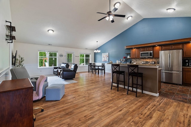 17309 E Baldwin Ave, Spokane Valley, WA 99016 - living room with a ceiling fan, dark wood-style flooring, high vaulted ceiling, a chandelier, and wainscoting