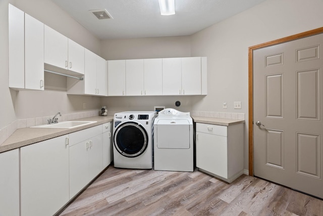 17110 E Daybreak Ln, Spokane Valley, WA 99016 - washroom with independent washer and dryer, cabinet space, and light wood-style flooring