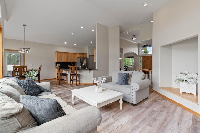 17110 E Daybreak Ln, Spokane Valley, WA 99016 - living area featuring light wood-style flooring, a chandelier, arched walkways, recessed lighting, and high vaulted ceiling