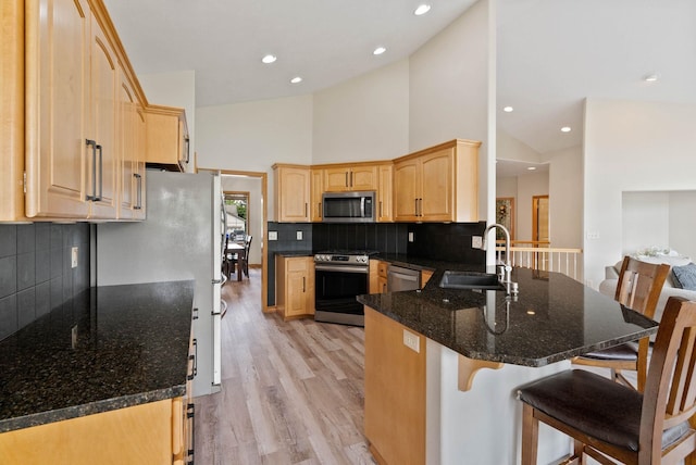 17110 E Daybreak Ln, Spokane Valley, WA 99016 - kitchen featuring stainless steel appliances, a peninsula, light brown cabinetry, a breakfast bar area, and light wood-type flooring
