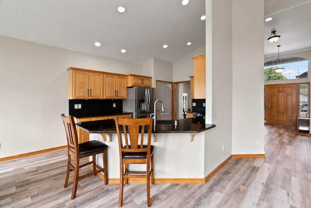 17110 E Daybreak Ln, Spokane Valley, WA 99016 - kitchen featuring stainless steel fridge, light wood-type flooring, a kitchen bar, a peninsula, and recessed lighting