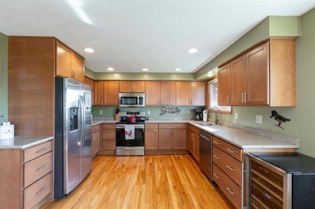 5801 N Drumheller St, Spokane, WA 99205 - kitchen featuring stainless steel appliances, beverage cooler, light wood-style flooring, brown cabinetry, and recessed lighting