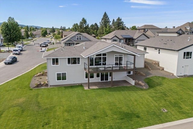 16931 E 16th Ln, Spokane Valley, WA 99037 - back of property featuring a residential view, a lawn, a shingled roof, a deck, and a patio