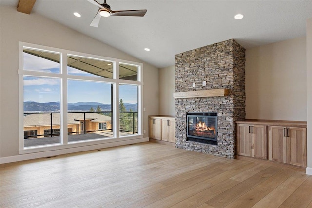 16931 E 16th Ln, Spokane Valley, WA 99037 - unfurnished living room featuring a mountain view, light wood finished floors, plenty of natural light, a stone fireplace, and recessed lighting
