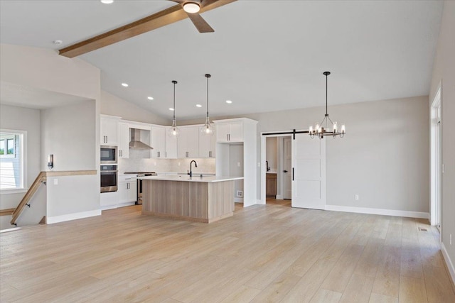16931 E 16th Ln, Spokane Valley, WA 99037 - kitchen featuring appliances with stainless steel finishes, wall chimney exhaust hood, a barn door, backsplash, and ceiling fan