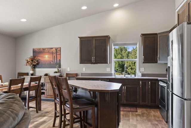 2373 N Colonial Rd, Liberty Lake, WA 99016 - kitchen featuring appliances with stainless steel finishes, light wood-style flooring, dark brown cabinetry, recessed lighting, and a center island