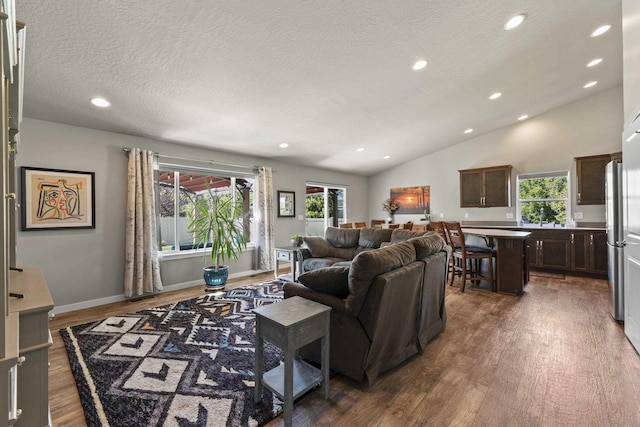 2373 N Colonial Rd, Liberty Lake, WA 99016 - living area with wood finished floors, a textured ceiling, lofted ceiling, and recessed lighting