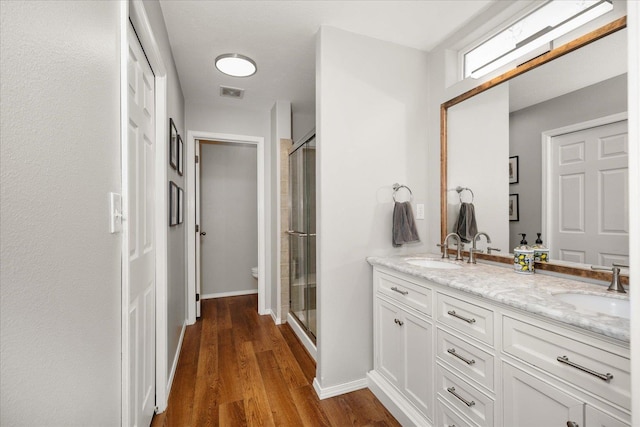 5916 S Division St, Spokane, WA 99224 - bathroom featuring double vanity, a shower stall, and wood finished floors