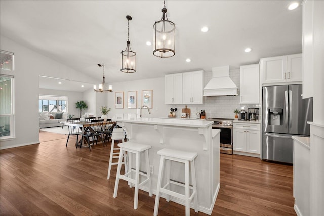 5916 S Division St, Spokane, WA 99224 - kitchen with stainless steel appliances, custom exhaust hood, light countertops, dark wood-style floors, and decorative backsplash