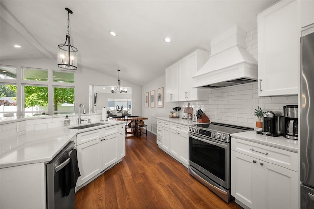 5916 S Division St, Spokane, WA 99224 - kitchen featuring appliances with stainless steel finishes, premium range hood, vaulted ceiling, backsplash, and dark wood-type flooring