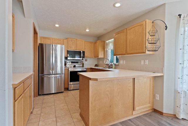 17813 N Lidgerwood St, Colbert, WA 99005 - kitchen with appliances with stainless steel finishes, light brown cabinets, a peninsula, light countertops, and recessed lighting