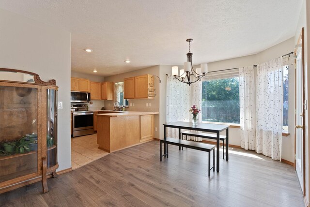 17813 N Lidgerwood St, Colbert, WA 99005 - kitchen with stainless steel appliances, light brown cabinets, a chandelier, light wood-style floors, and light countertops