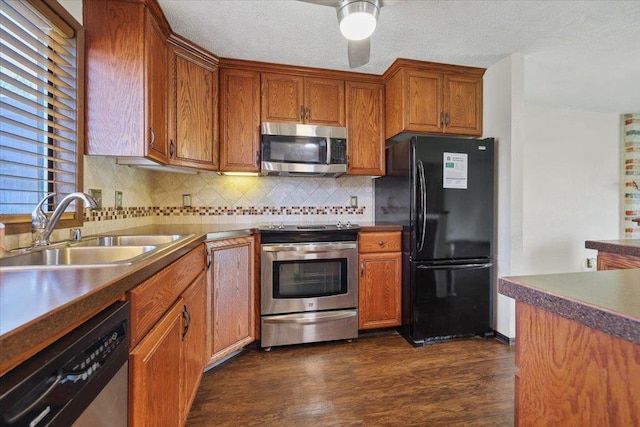 417 Clay St Unit A, Cheney, WA 99004 - kitchen featuring appliances with stainless steel finishes, dark wood finished floors, backsplash, brown cabinetry, and dark countertops