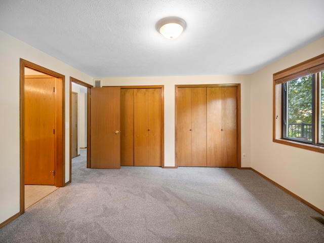 3808 S Alder Dr, Spokane, WA 99223 - unfurnished bedroom featuring multiple closets, light colored carpet, and a textured ceiling