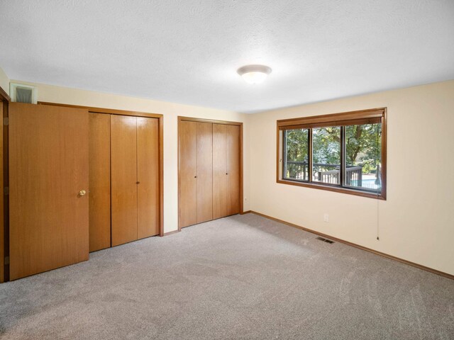 3808 S Alder Dr, Spokane, WA 99223 - unfurnished bedroom with multiple closets, carpet flooring, and a textured ceiling
