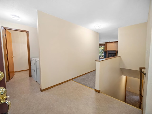 3808 S Alder Dr, Spokane, WA 99223 - hallway featuring washer and dryer, an upstairs landing, and light carpet