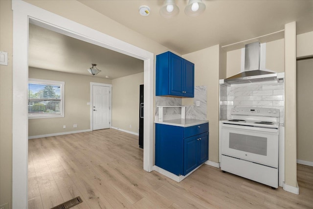 2323 E Rich Ave, Spokane, WA 99207 - kitchen featuring white electric range oven, wall chimney exhaust hood, blue cabinetry, light wood-style floors, and decorative backsplash