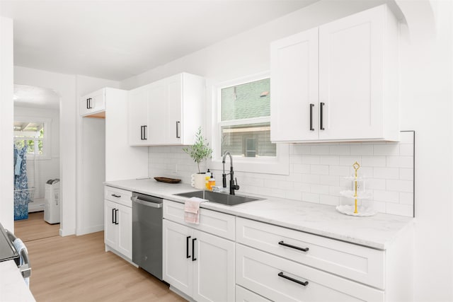 1227 E Providence Ave, Spokane, WA 99207 - kitchen with stainless steel dishwasher, white cabinets, light wood-style floors, decorative backsplash, and light stone counters