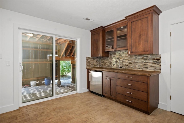 8024 E Elde Dr, Spokane, WA 99212 - kitchen featuring dark countertops, refrigerator, backsplash, and glass insert cabinets