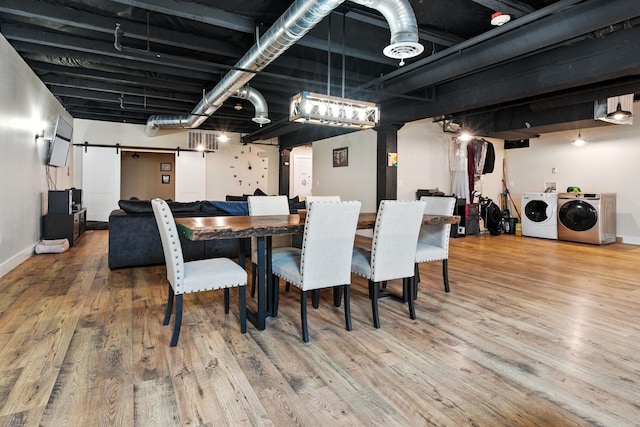 315 W Riverside Ave Unit 101, Spokane, WA 99201 - dining area featuring a barn door, washer and clothes dryer, and wood finished floors